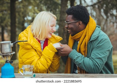 Caucasian couple camping, active romantic couple in love traveling and hiking. Tourists are exploring together. Sunny autumn day. They warm up while drinking hot drinks. Travel concept - Powered by Shutterstock