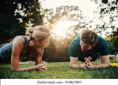 Caucasian Couple Doing Core Workout Together In Park. Fit Young Man And Woman Exercising.