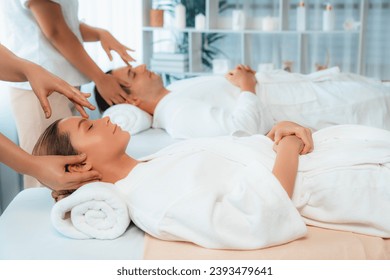 Caucasian couple enjoying relaxing anti-stress head massage and pampering facial beauty skin recreation leisure in dayspa modern light ambient at luxury resort or hotel spa salon. Quiescent - Powered by Shutterstock