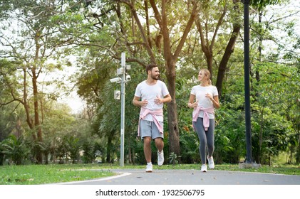 Caucasian Couple Jogging In Garden. Family Holiday Morning Workout. Take Are Of Your Physical Health Makes You Healthy. Concept Health Insurance