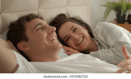 Caucasian couple man woman lying on bed home discussing plans chatting talking laughing happiness girlfriend boyfriend honeymoon romance togetherness intimate loving affection relax unity family smile - Powered by Shutterstock