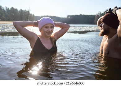 Caucasian Couple Swimming In Frozen Lake