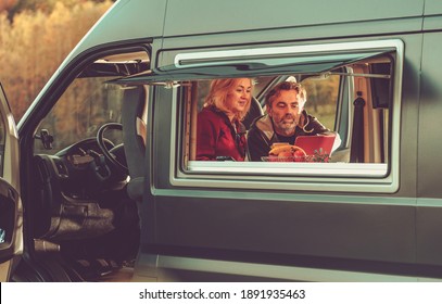 Caucasian Couple Watching Movie Online Inside Their Modern Camper Van During Their Weekend Getaway. Recreational Vehicle RV and Camping Theme. - Powered by Shutterstock