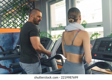 Caucasian Couple Working Out Together On Treadmill. Medium Indoor Shot. Gym Clothing And Health Benefits Concept. High Quality Photo