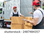 Caucasian delivery man checking a list of delivering package in truck. Attractive courier postman worker team in uniform working and preparing to load deliver box cardboard postal from car van.