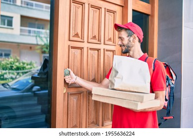 Caucasian delivery man wearing red uniform and delivery backpack smilly happy outdoors holding pizza box - Powered by Shutterstock