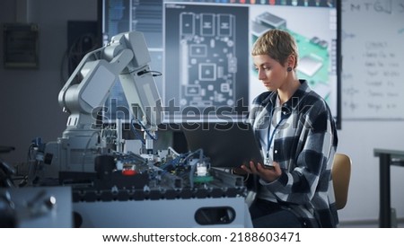 Caucasian Developer Writing Code at Laptop while Working with Robotic Arm. Startup and Programming at Laboratory. High-Tech Science, Robotics and Research at University of Technology Concept.