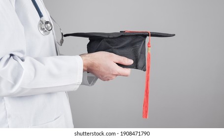 Caucasian Doctor Holding Graduation Hat. Medical Education