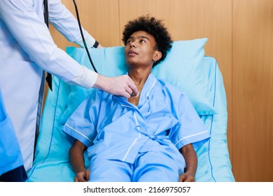 Caucasian Doctor With Nurse And Black Man Patient. Doctor Talking Consulting And Checkup By Stethoscope With Patient. Hospital Healthcare And Medicine Concept.