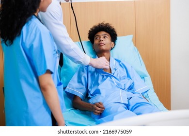 Caucasian Doctor With Nurse And Black Man Patient. Doctor Talking Consulting And Checkup By Stethoscope With Patient. Hospital Healthcare And Medicine Concept.