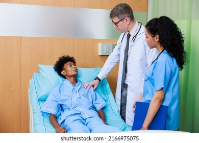 Caucasian Doctor With Nurse And Black Man Patient. Doctor Talking Consulting And Checkup By Stethoscope With Patient. Hospital Healthcare And Medicine Concept.