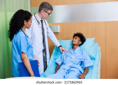 Caucasian Doctor With Nurse And Black Man Patient. Doctor Talking Consulting And Checkup By Stethoscope With Patient. Hospital Healthcare And Medicine Concept.