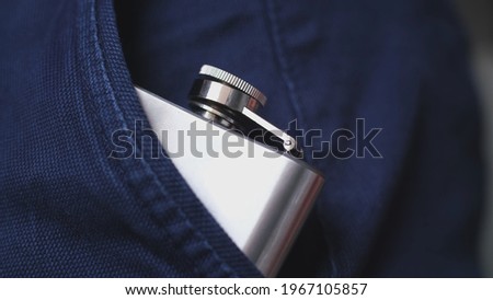 Caucasian Drinking Man Pulling Out and Putting In Shiny Metal Hip Flask of Whiskey Alcohol Concealed in Trousers Pocket