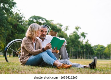Caucasian Elderly Couple Relaxing And Sitting At The Park Reading The Retirement Plan To Discussing Together, Happy Marriage Couple Lifestyle, Worry Free Retirement Insurance, Love And Cherish Couple.