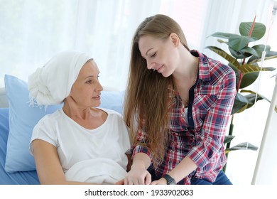 Caucasian Elderly Mother In White Headscarf Is Laying On Bed In Hospital After Chemotherapy Because She Is Suffering From Cancer Or Leukemia Patient And Young Daughter Is Hugging And Caring Her Mom.