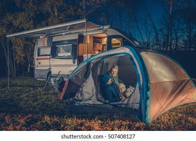 Caucasian Family Camping Fun. Caucasian Family In The Tent. RV Motorhome Camper In The Background.