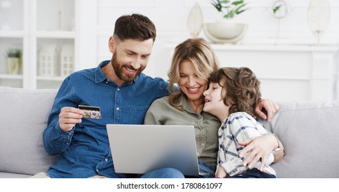 Caucasian Family With Child Spending Money Together On Sofa At Home. Parents With Son Using Laptop To Buy Online With Credit Card. Kid With Mother And Father Shopping In Internet On Computer.