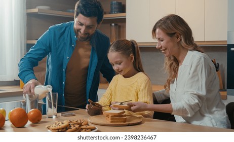 Caucasian family cooking breakfast together at kitchen at home mother with little daughter child girl prepare toasts bread with chocolate pasta father pour milk into glasses parents with kid cook - Powered by Shutterstock