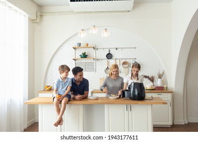 The Caucasian family Make breakfast with the air fryer together.  father, mother, daughter and sons Cooking in the kitchen together at home. Happy family relationship and technology concept