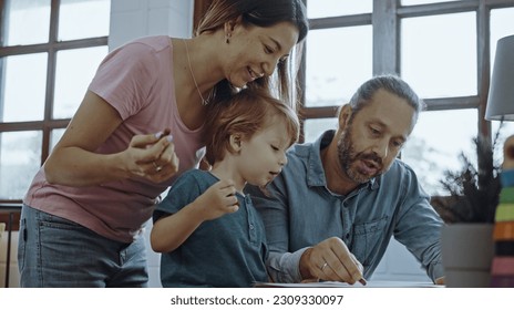 Caucasian family painting paper and son indoors in house  Little son learn how to draw art picture enjoy creativity and mother   father in house 