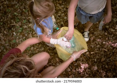 Caucasian Family Picking Up Trash To Garbage Bag From Forest 