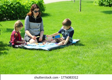 Caucasian Family Playing Board Games At The Picnic Outdoors