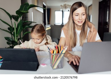 Caucasian family working and studying online at home and using laptop. Distance or remote learning for child. Pretty stylish schoolgirl studying homework math during coronavirus covid-19 quarantine - Shutterstock ID 2120576798