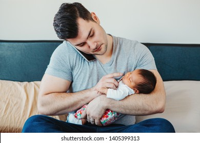 Caucasian Father Dad With Newborn Mixed Race Asian Chinese Baby Working From Home. Male Man Parent Holding Child Daughter Son Talking Over Phone. Single Dad Family. Genderblend Concept