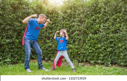 Caucasian father daughter child girl playing in spring or summer park outdoors. Daddy and child girl in Superhero costumes. Happy family love together single dad lifestyle father's day holiday concept
