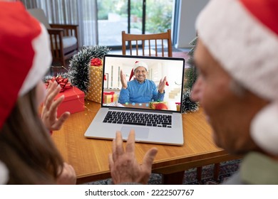 Caucasian father and daughter with santa hats having video call with happy biracial man. Christmas, celebration and digital composite image. - Powered by Shutterstock