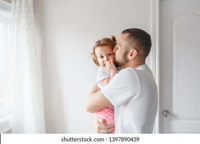 Caucasian Father Hugging And Kissing Toddler Baby Girl. Parent Hugging Embracing Child Daughter. Authentic Lifestyle Touching Tender Moment. Single Dad Family Life Concept. Happy Fatherhood.