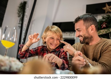 Caucasian father and son playing during Christmas dinner. Happy family of two person - Shutterstock ID 2229800099