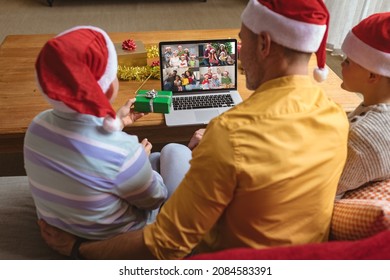 Caucasian Father And Sons In Santa Hats Making Laptop Christmas Group Video Call With Four Families. Christmas, Festivity And Communication Technology.