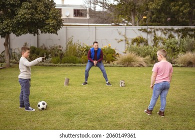 Caucasian father and two sons playing football together in the garden. fatherhood and love concept - Powered by Shutterstock