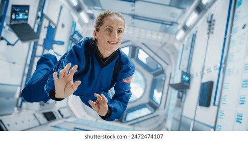 Caucasian Female Astronaut Floating in Space Station, Wearing Blue Spacesuit, Smiling. Demonstrates Human Achievement in Space Exploration. Cosmos Encourages Scientific Discovery Concept. - Powered by Shutterstock