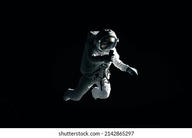 Caucasian female astronaut using her mobile phone during spacewalk, messaging, taking pictures - Shutterstock ID 2142865297