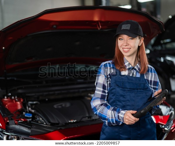 Caucasian female auto mechanic uses a special computer\
to diagnose faults. 