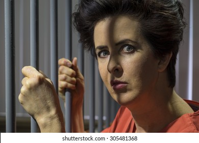 Caucasian Female Behind Bars In A Jail Cell