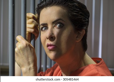 Caucasian Female Behind Bars In A Jail Cell