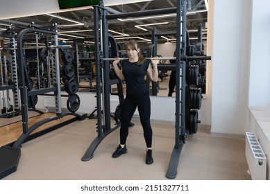 Caucasian Female Bodybuilder Does Barbell Squats In Smith Machine In Fitness Gym, Sport Healthy Lifestyle