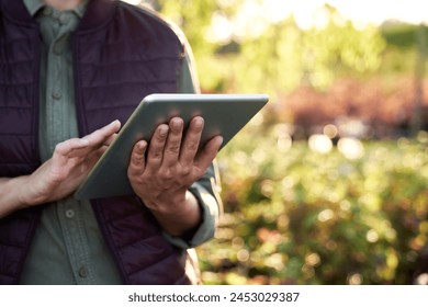 Caucasian female botanist standing in the greenhouse and using digital tablet - Powered by Shutterstock