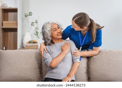 A Caucasian female doctor provides encouragement and advice on maintaining good health to an elderly Asian patient while they sit together on the sofa. - Powered by Shutterstock