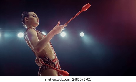 Caucasian Female Gymnast in Sparkling Costume, Expertly Performing With Clubs Under Bright Stadium Lights, Her Strength, Precision, and Artistry in Mesmerizing Rhythmic Gymnastics Routine. - Powered by Shutterstock