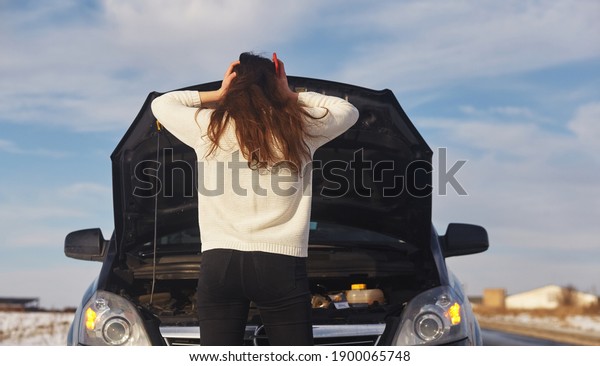 Caucasian female having a problem with\
car on a roadtrip Upset woman emotionally reacting on overheated\
car standing on the roadside with the open\
hood