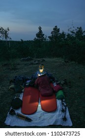 Caucasian Female Hiker Reading Book/writing Journal At Night While Wildcamping, Strong Light From Headlamp