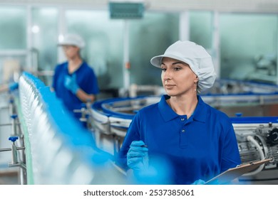 Caucasian female industry worker team working in factory warehouse. Attractive women industrial processing bottles of mineral water orders and food product at manufactory warehouse with happiness. - Powered by Shutterstock