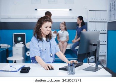 Caucasian female nurse using the computer desktop, to verify patient information and appointments, while male doctor assists mother and daughter. A scene of healthcare and communication. - Powered by Shutterstock