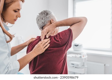 Caucasian female orthopedist examining senior male patient's back in clinic. Spinal injury treatment prevention. Chiropractic concept. Healing process - Powered by Shutterstock