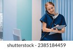 Caucasian female practitioner working at reception desk while answering phone calls and scheduling appointments in medical clinic. Hospital concept.