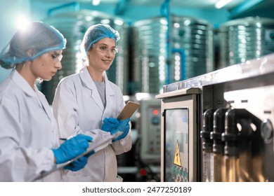 Caucasian female scientist working in laboratory at factory warehouse. Attractive two chemist analysis of a chemical sample in the scientific research laboratory processing bottles of mineral water. - Powered by Shutterstock